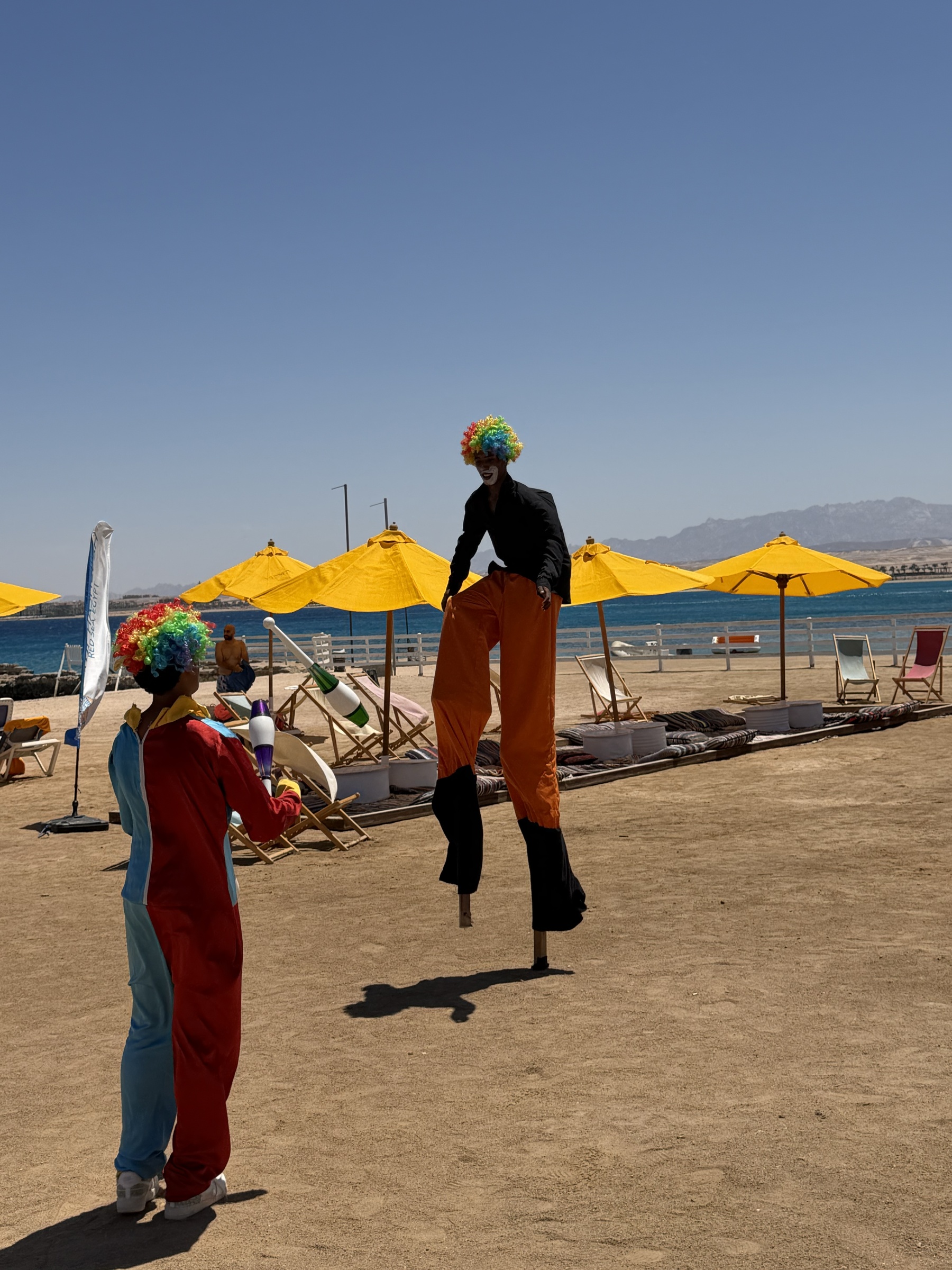 A stilt walker and juggler entertaining guests at the Sahl Hasheesh beach event