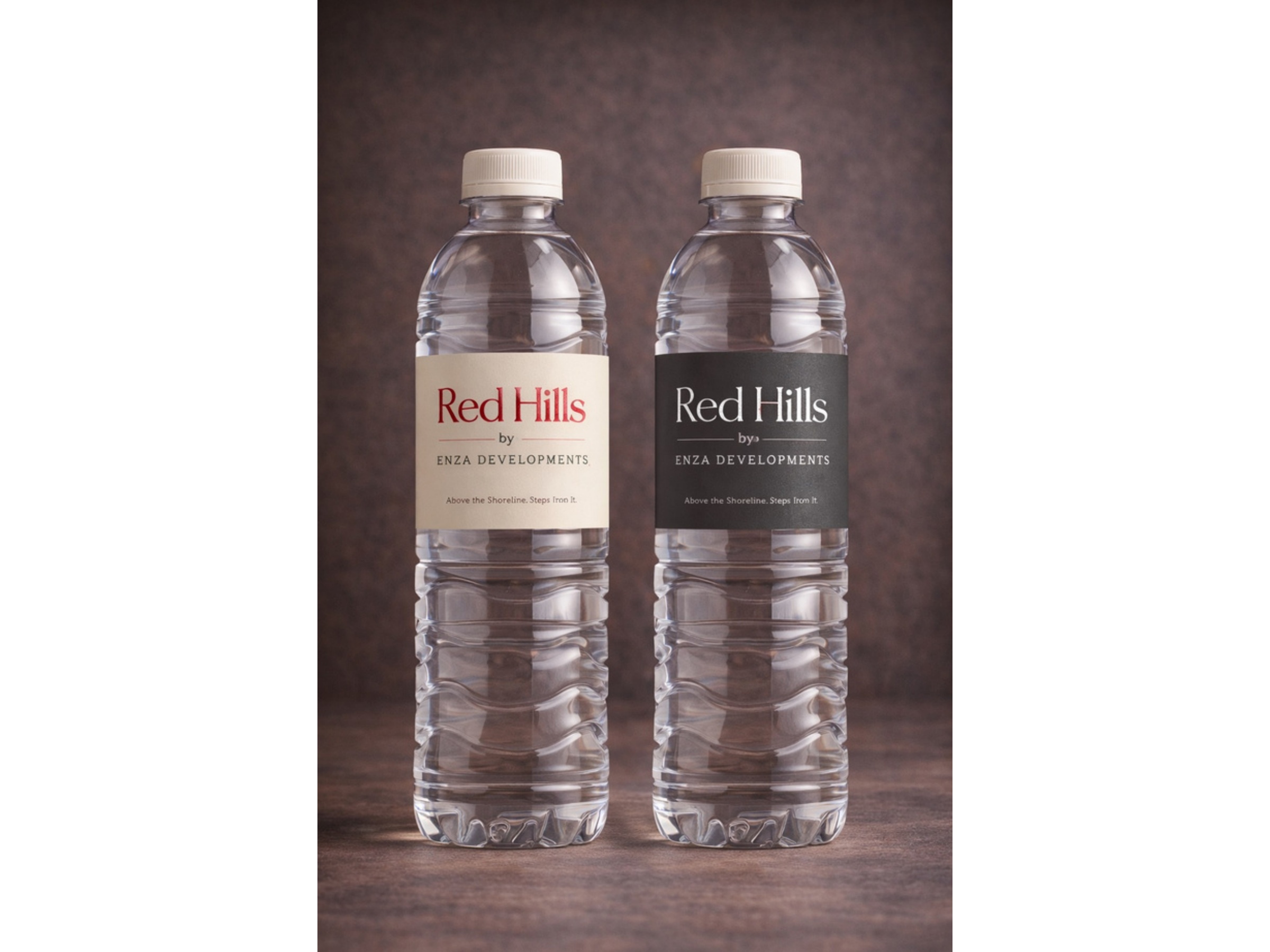 Two water bottles with beige and dark Red Hills branded labels
